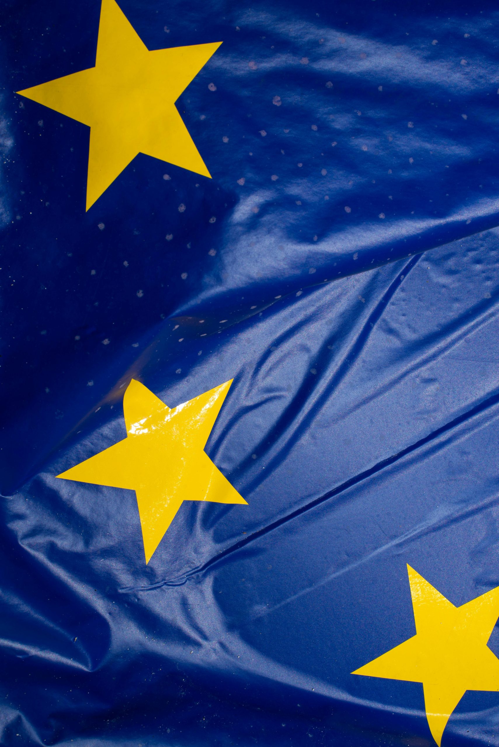 Detailed view of the European Union flag featuring yellow stars on a blue background.